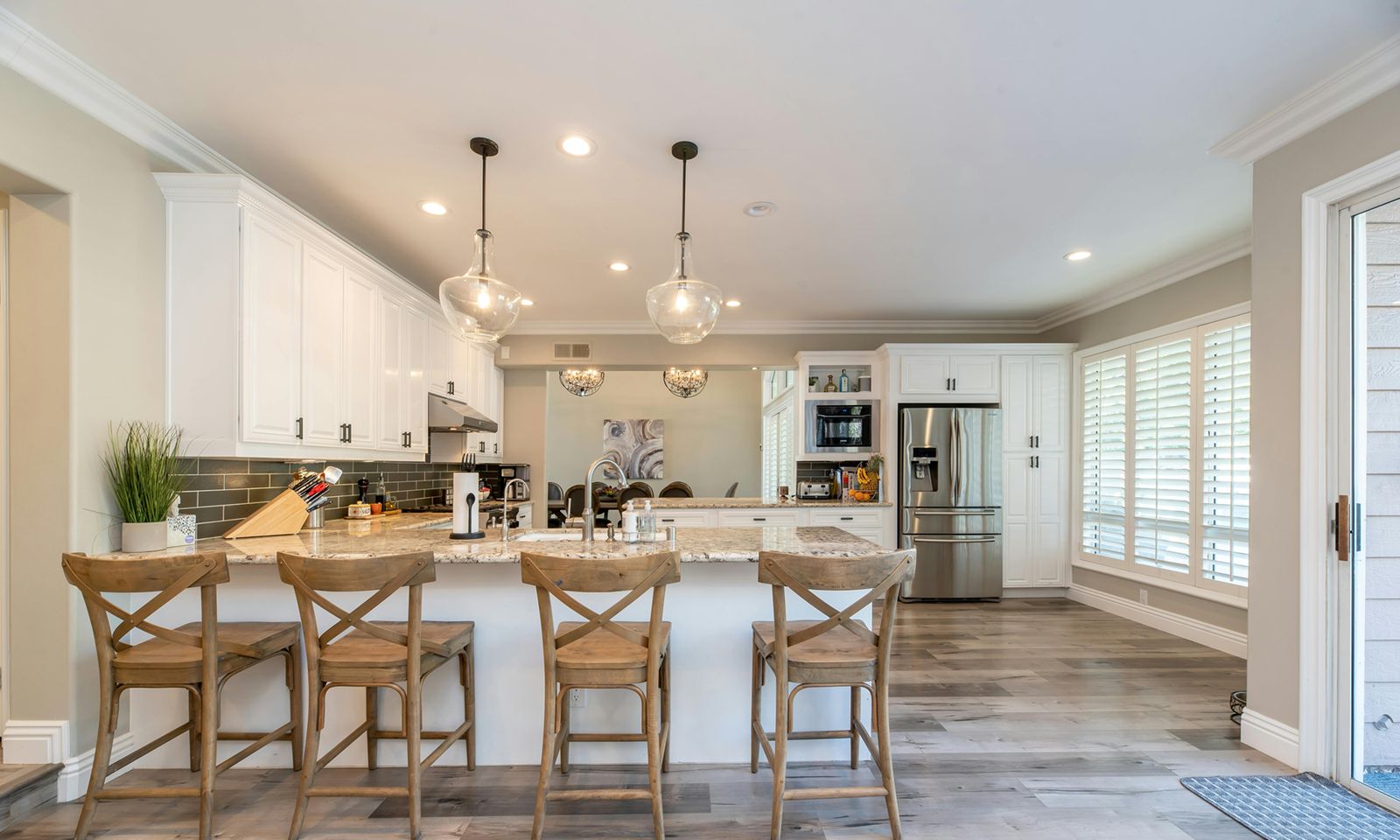White kitchen with a breakfast bar and pendant lights